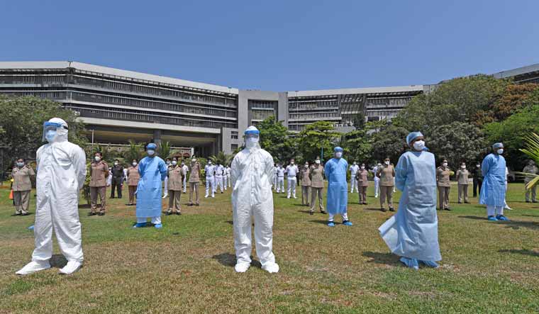 Hospital workers in PPE and wearing masks stand together awaiting the Indian Air Force's petal-dropping display on May 3 | Amey Mansabdar