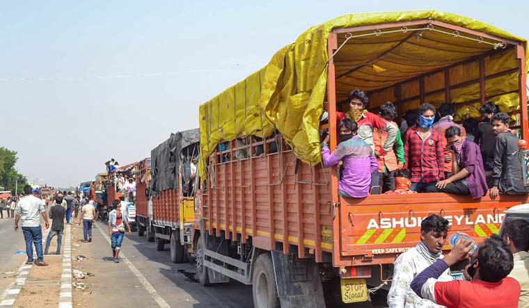 Migrant workers travel in crowded trucks during the ongoing COVID-19 lockdown, on the outskirts of Lucknow | PTI