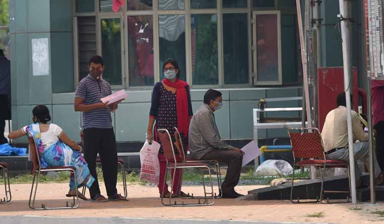 Suspected COVID-19 patients wait to be examined by medics at a government hospital in East Delhi | PTI