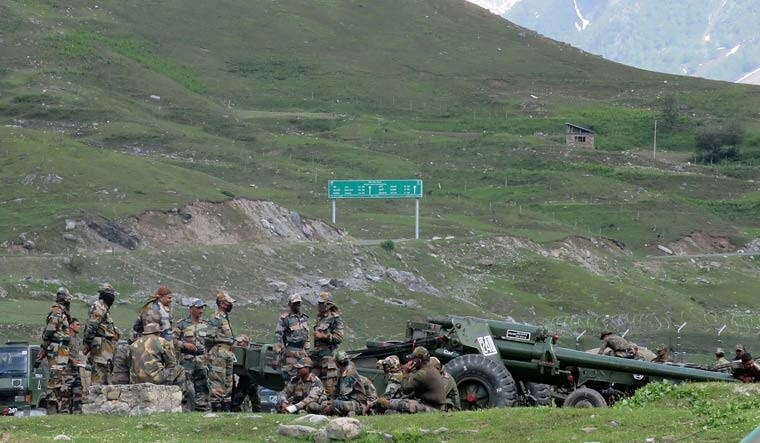 Indian Army soldiers rest next to artillery guns at a makeshift transit camp before heading to Ladakh, near Baltal, southeast of Srinagar, on Tuesday | Reuters