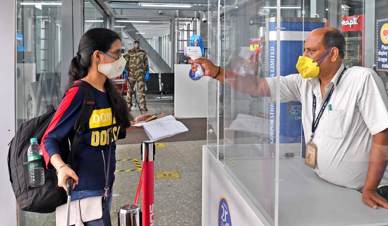 An official uses a thermal screening device on a passenger at Kolkata airport | Salil Bera
