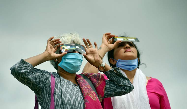 Women look through 3D glasses to get a glimpse of solar eclipse, in Bengaluru | PTI