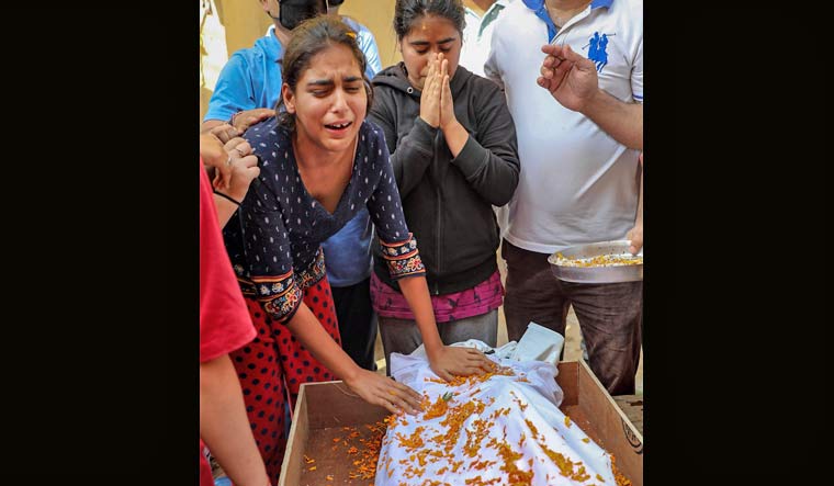 Wife and other family members of Kashmiri Pandit sarpanch Ajay Pandita mourn near his mortal remains, at their residence in Jammu | PTI