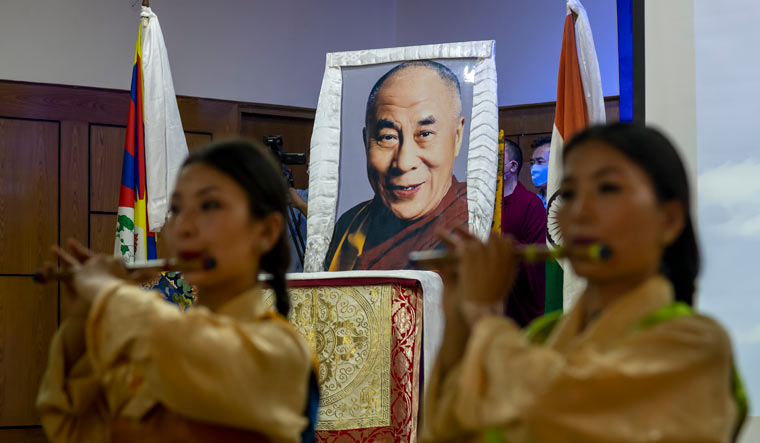 Exile Tibetan artists perform a special song to mark the 85th birthday of their spiritual leader the Dalai Lama whose portrait is seen behind at an official function in Dharamsala | AP