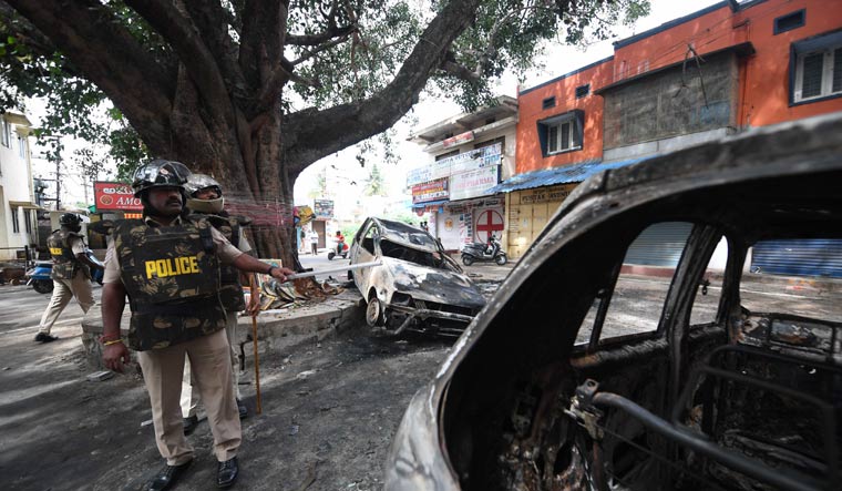 Police guard a street in an area at DJ Halli following large-scale violence and arson | Bhanu Prakash Chandra