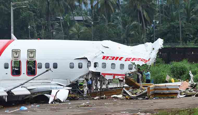 Officials inspect the site where a passenger plane crashed when it overshot the runway at Kozhikode airport | Reuters