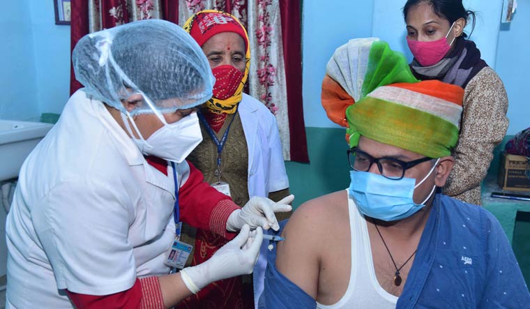 A medic administers the first dose of Covishield vaccine on frontline worker Pawan Saraswat, at a city dispensary in Bikaner | PTI
