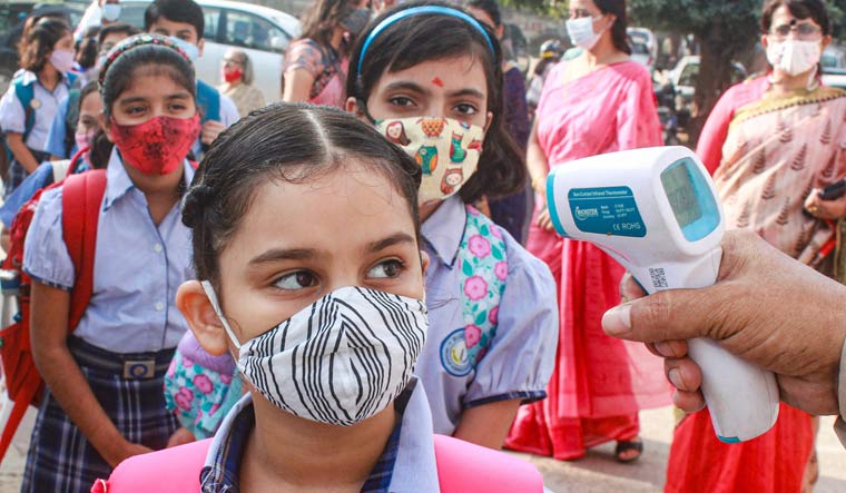 Students undergo thermal screening after authorities allowed schools to conduct classes for students of 1st to 5th standard as part of easing of COVID-19 induced restrictions, in Gurugram | PTI