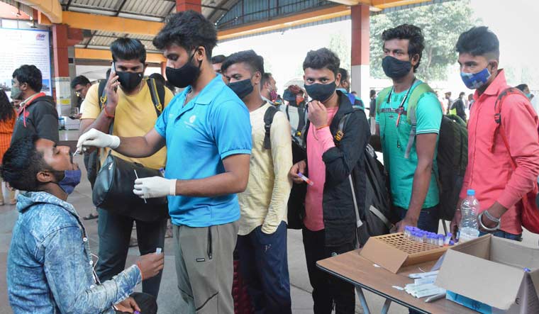 A medic collects swab sample of a passenger for COVID-19 test in Bengaluru | PTI