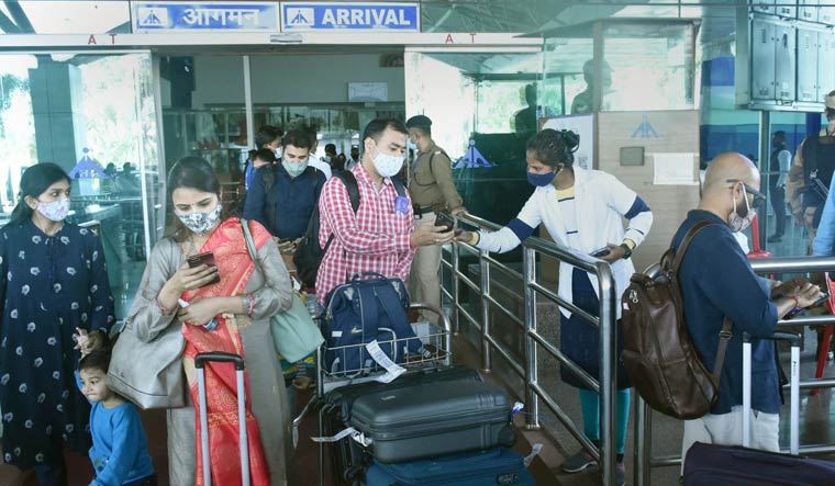 Passengers show their COVID-19 double dose certificates to health workers at Birsa Munda International Airport in Ranchi | PTI