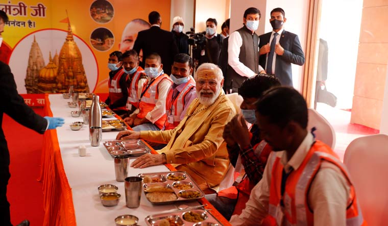 Prime Minister Narendra Modi sits for a meal with workers during the inauguration of Kashi Vishwanath Dham Corridor | AP