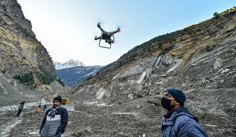 An IIT technician flies a drone to survey and map the damage near Raini village in Uttarakhand | PTI