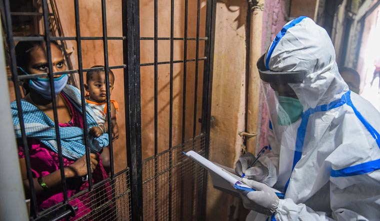 A health worker interacts with a resident of Dharavi slum during door-to-door screening for COVID-19 testing, in Mumbai | PTI
