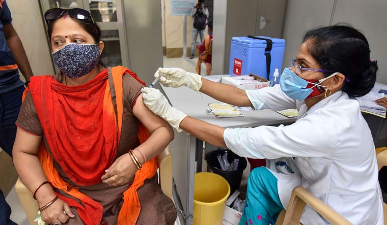 A medic administers COVID-19 vaccine to a woman at the Moti Lal Nehru Medical College, in Prayagraj | PTI
