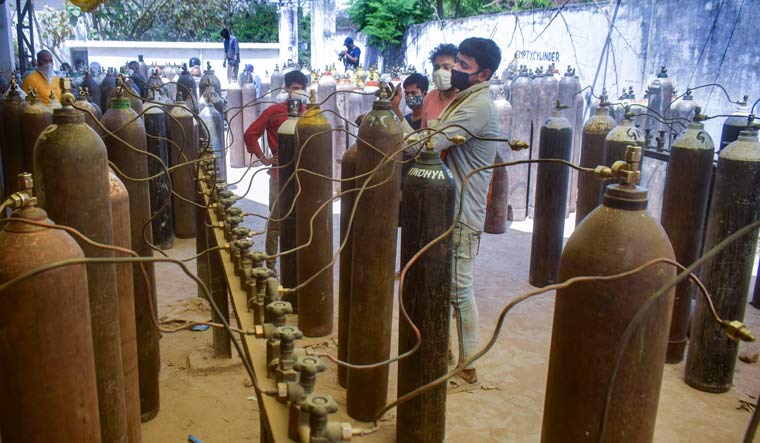 A worker sorts cylinders filled with medical oxygen at a plan in Prayagraj | PTI