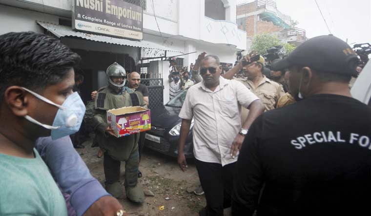 Uttar Pradesh ATS personnel carry a pressure cooker bomb and other heavy explosives recoverved after arresting two accused allegedly linked with Al Qaeda module, in Dubagga area of Lucknow | PTI