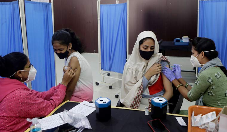 Health workers administer COVID-19 vaccine to women at a vaccination centre in Mumbai | PTI