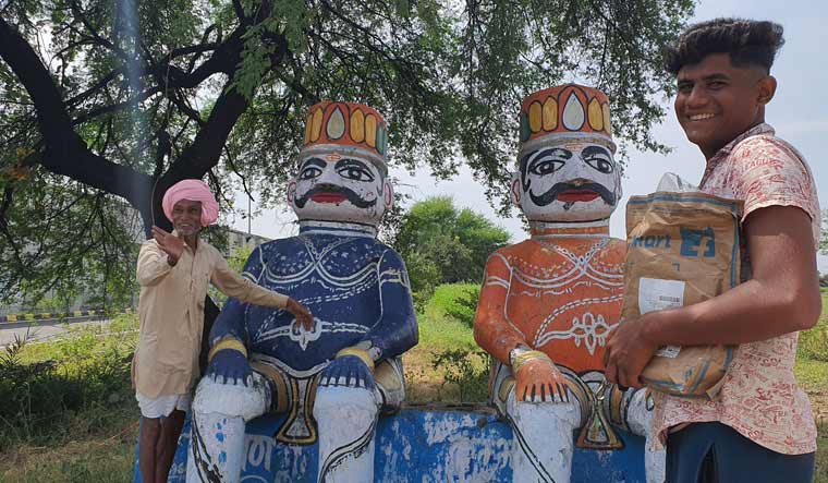 Kaluram Yadav, a village elder, talks about the Ravana-Kumbhakarna association with Bhatkhedi as his grandson Abhishek looks on.