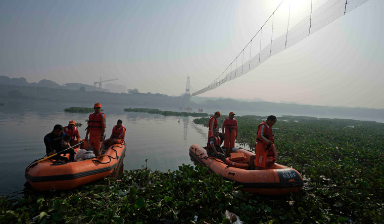 Rescuers on boats search for victims in the Machchhu river next to a cable bridge that collapsed on Sunday in Morbi town | AP