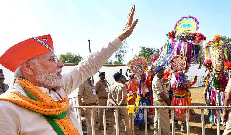 Prime Minister Narendra Modi waves at supporters during a public meeting at Kaprada in Valsad district of Gujarat | PTI