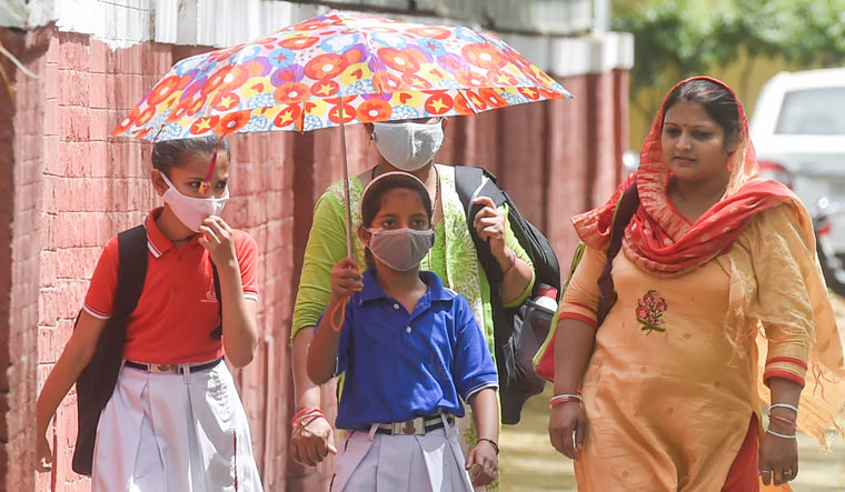 School students wearing masks return from school in Delhi | PTI