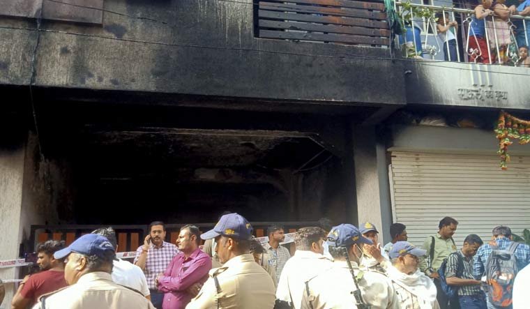 Police personnel stand guard after a fire broke out in a building, in Indore | PTI