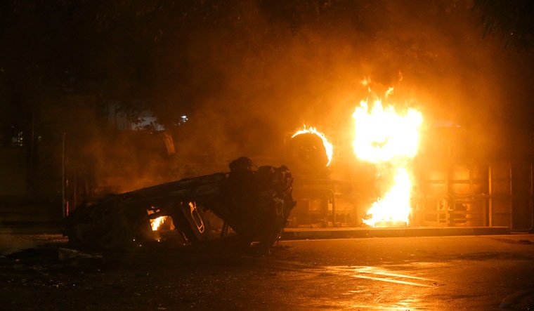 Vehicles of Sri Lanka's ruling party supporters burn after set on fire during a clash with anti-government demonstrators | Reuters