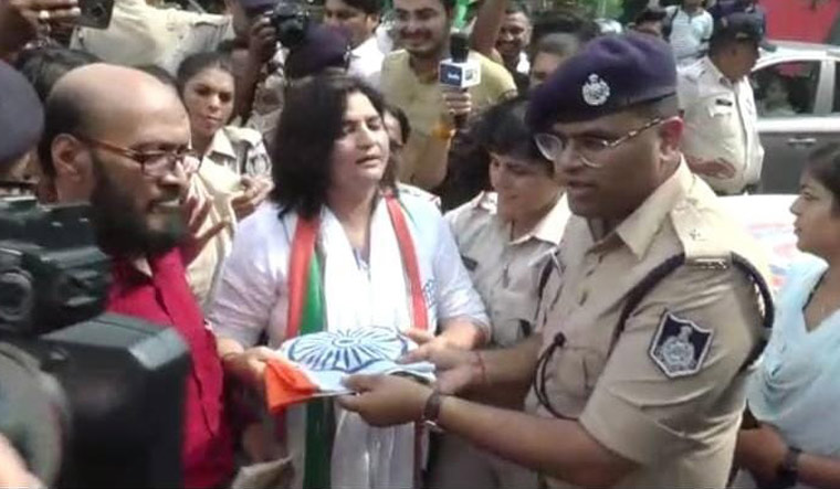 Madhya Pradesh Congress media cell vice-president Sangeeta Sharma hands over the national flag to police officers.