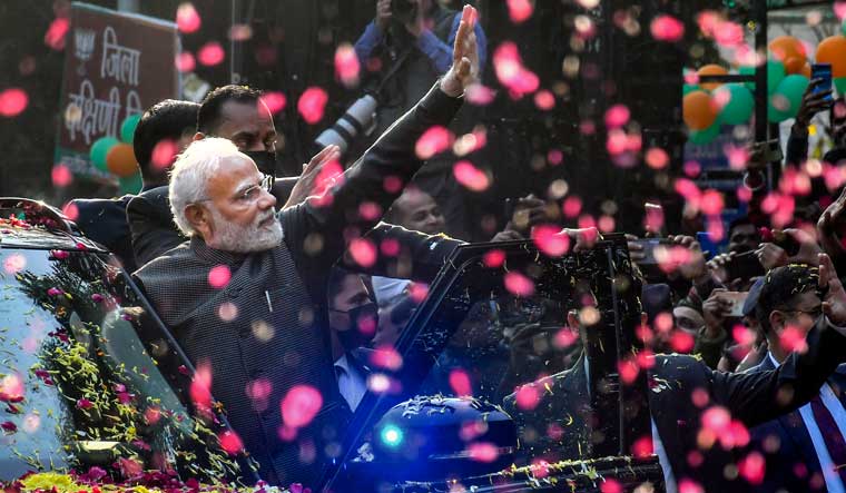 Prime Minister Narendra Modi waves at supporters during a roadshow in Delhi | PTI