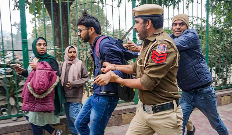 Delhi Police personnel detain a student during a protest over the screening of the BBC documentary on Prime Minister Narendra Modi, at the Jamia Millia Islamia campus | PTI