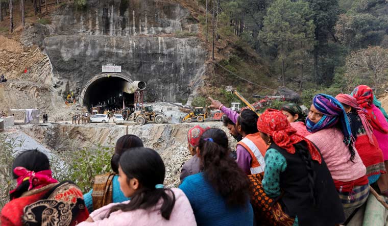 People wait outside the Silkyara tunnel where rescue operations are underway to rescue trapped workers | Reuters