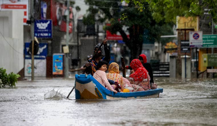 Residents shift to a safer place from a flooded area during heavy rain owing to Cyclone Michaung, in Chennai | PTI