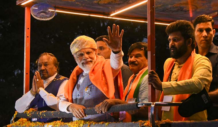 Prime Minister Narendra Modi waves at supporters during a roadshow in Mysuru | PTI