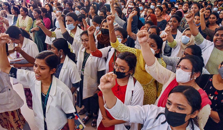 Doctors and medical students at Kochi Government Medical College Hospital raise slogans during their protest against the killing of a female surgeon | PTI