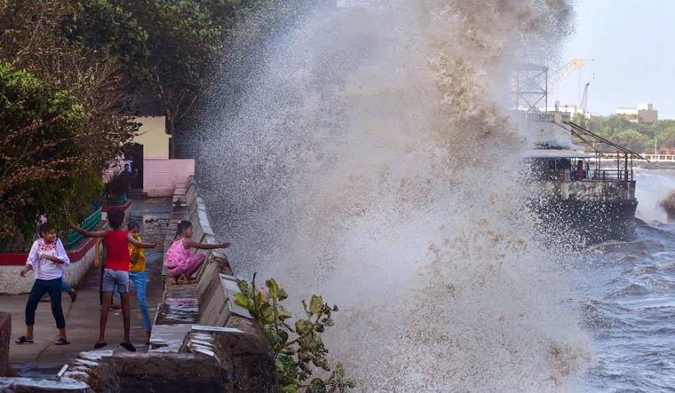 Children play as high tides crash at the sea front at Colaba in Mumbai, ahead of cyclone Biparjoys landfall in Kutch | PTI