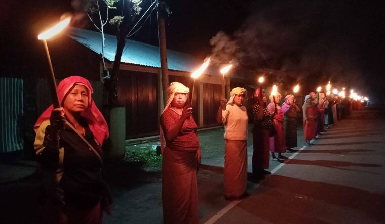 People in large numbers take part in a torchlight vigil in response to the ongoing violence in Manipur, in Bishnupur | PTI