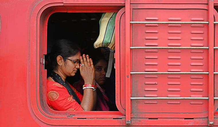 A woman passenger on board the Coromandal Express prays as the train leaves Shalimar station | Salil Bera