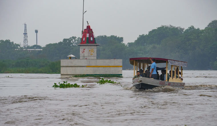 People take ride on a boat in Yamuna river after heavy monsoon rains, in New Delhi | PTI