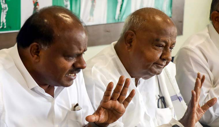 Former prime minister and JD(S) supremo H.D. Deve Gowda and former Karnataka chief minister HD Kumaraswamy address a press conference in Bengaluru | PTI