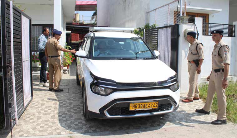 Police personnel outside a residential premises during a raid by NIA in Dehradun | PTI