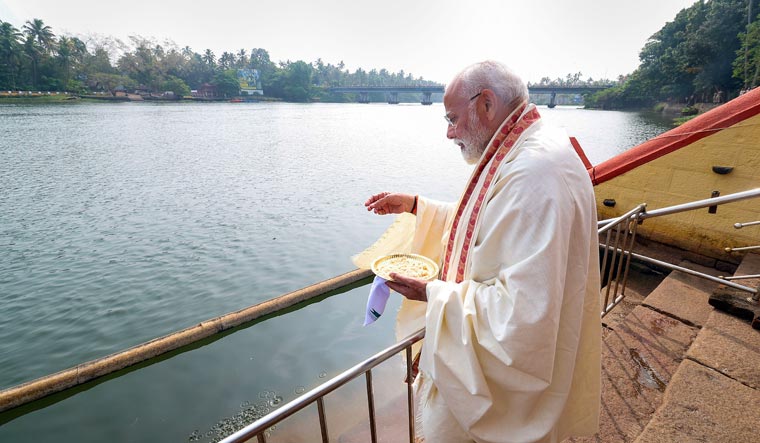 Prime Minister Narendra Modi feeds fish during a visit to Triprayar Sree Ramaswamy Temple in Kerala | PTI