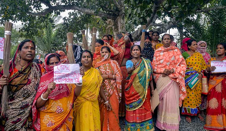 Women holding posters stage a protest demanding the arrest of local TMC leaders over Sandeshkhali incident allegations, in North 24 Parganas district | PTI