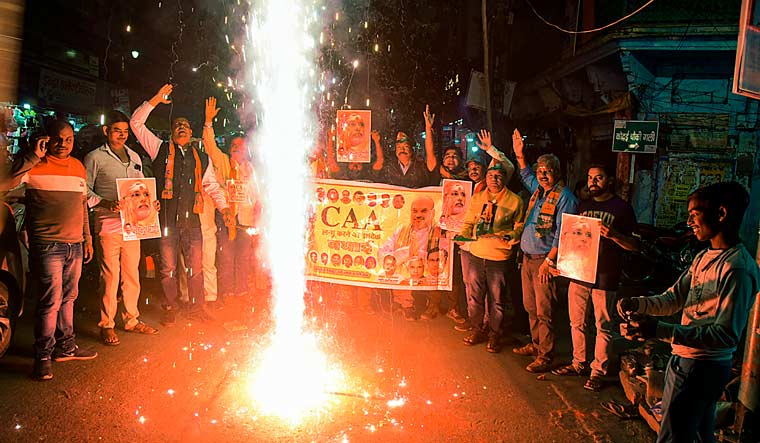 BJP workers celebrate after the central government notified the rules for implementation of the Citizenship (Amendment) Act, in Varanasi | PTI