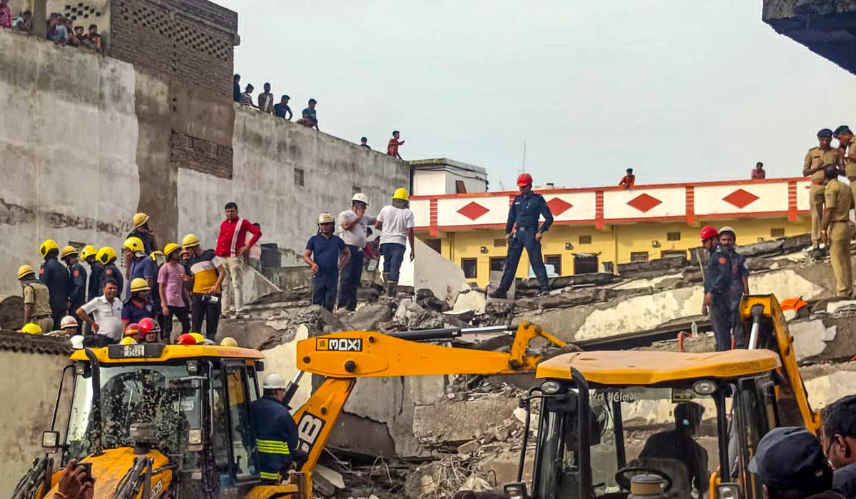 Officials and others during a rescue operation after a building collapse, in Surat | PTI