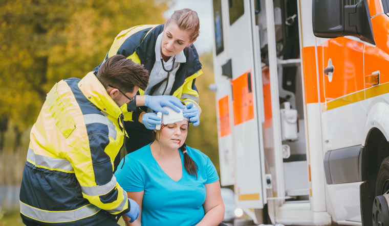 Emergency-medics-dressing-head-wound-blood-injury-woman-accident-shut
