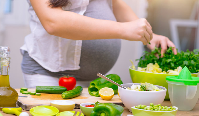pregnancy-pregnant-woman-cooks-food-leaf-vegetables-nutrition-fibrre-food-shut