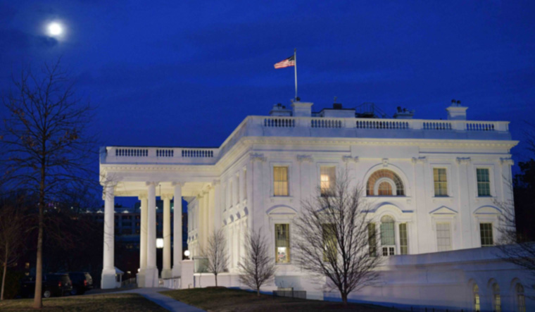 The moon is seen above the White House 