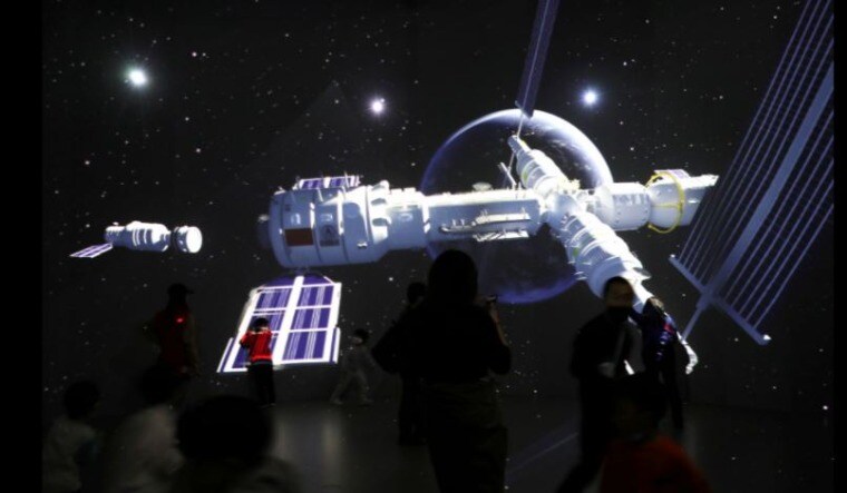 Visitors stand near a giant screen displaying the images of the Tianhe space station at an exhibition featuring the development of China's space exploration on the country's Space Day at China Science and Technology Museum in Beijing, China April 24, 2021 | Reuters