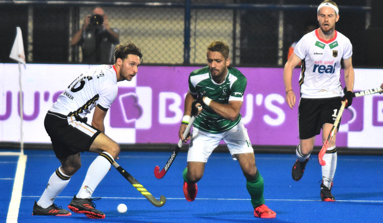 Germany's Johannes Grosse (left) and Ammad Butt (right) vie for the ball during the group stage match at the 2018 Hockey World Cup in Bhubaneswar | AFP