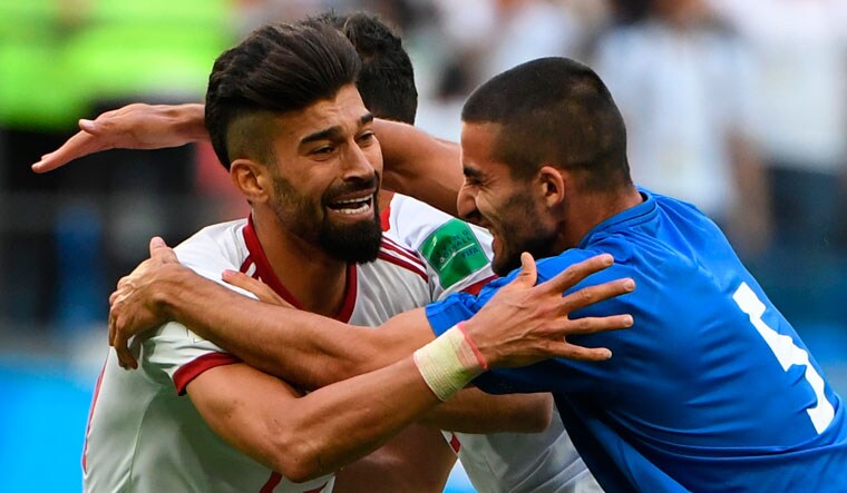 Iran's defender Ramin Rezaian (L) and Iran's defender Milad Mohammadi celebrate after the final whistle of the Russia 2018 World Cup Group B football match between Morocco and Iran at the St Petersburg Stadium in St Petersburg | AFP